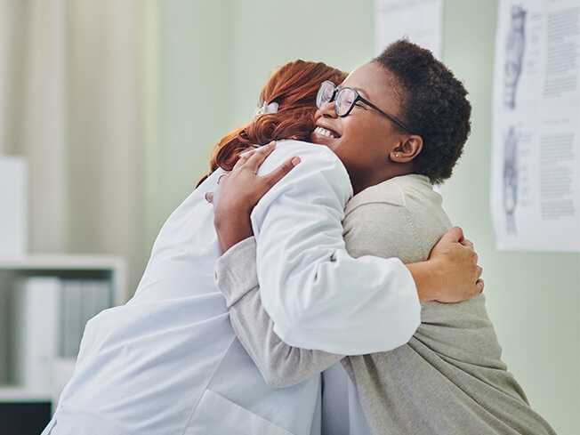 Female physician hugging a female patient