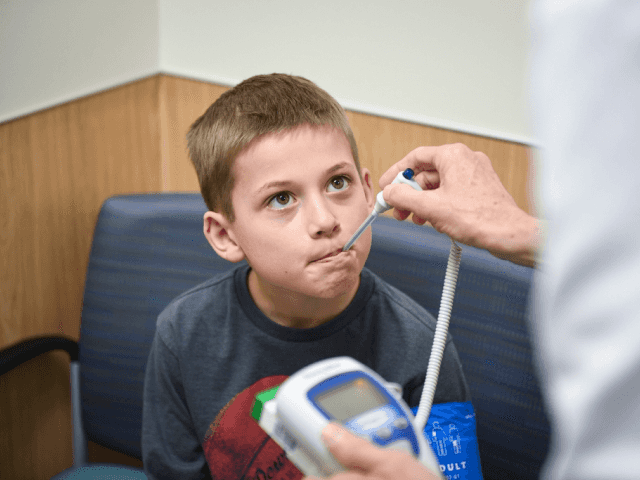 Child getting their temperature taken by a provider.