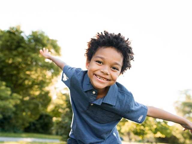 Smiling Black boy with outstretched arms