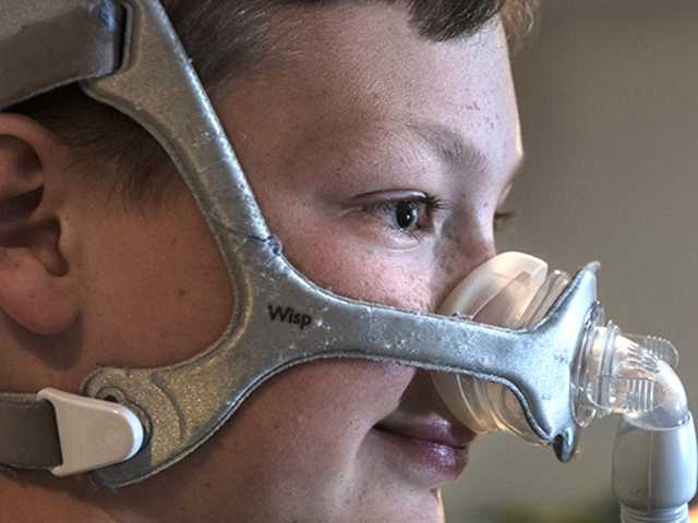 Preteen boy with a breathing mask over his nose