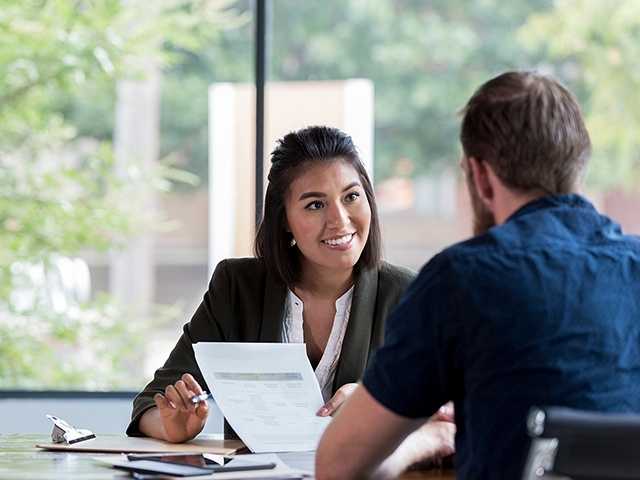 Woman discusses financial paperwork with man