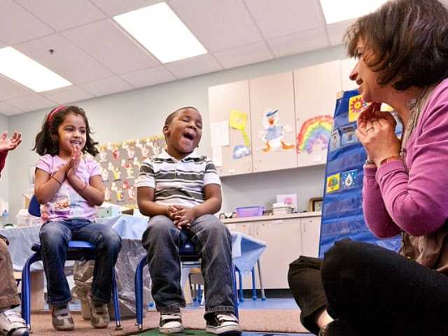 Female working with group of young children.