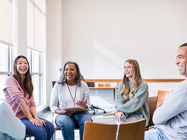 group of people in a room talking and laughing