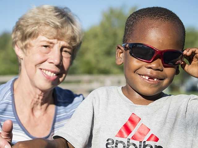 Smiling young black boy wearing sunglasses in the sunshine