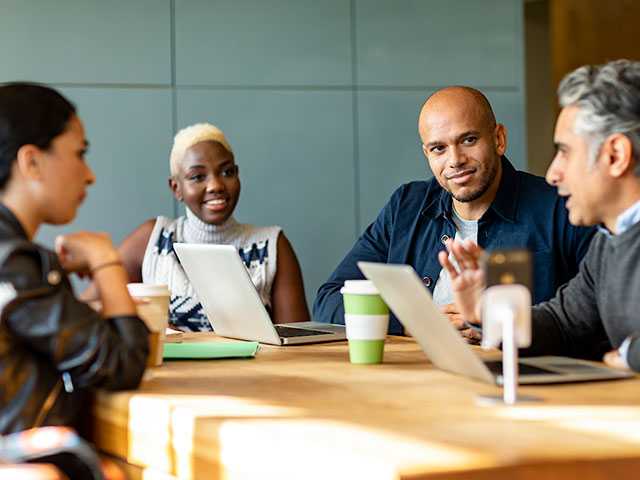 Black man and woman sit at a table having a conversation