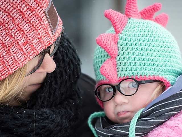 Young daughter being held by mother.