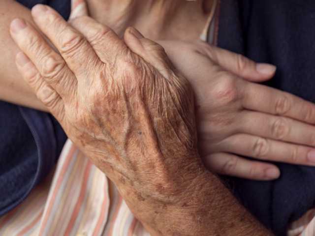 Doctors comforting elderly patient