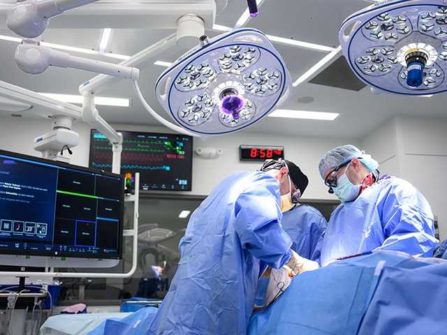 Cardiovascular surgeon performs surgery in operating room.